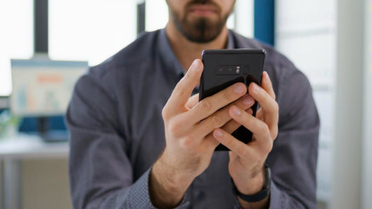 A man busy reading/looking at his smartphone. Using your smartphone to monitor mental health.