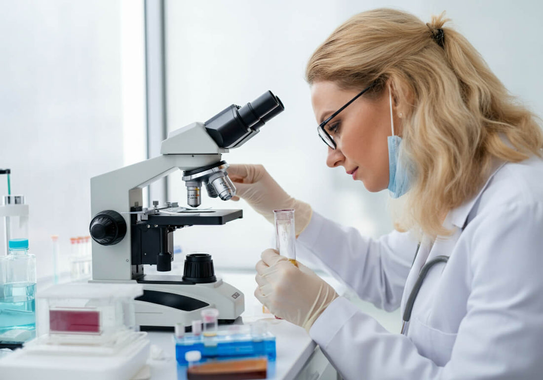 A woman looking at a urine sample under the microscope