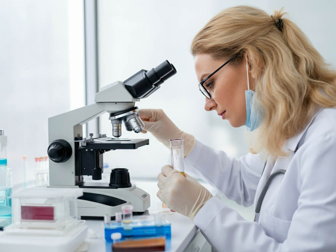 A woman looking at a urine sample under the microscope